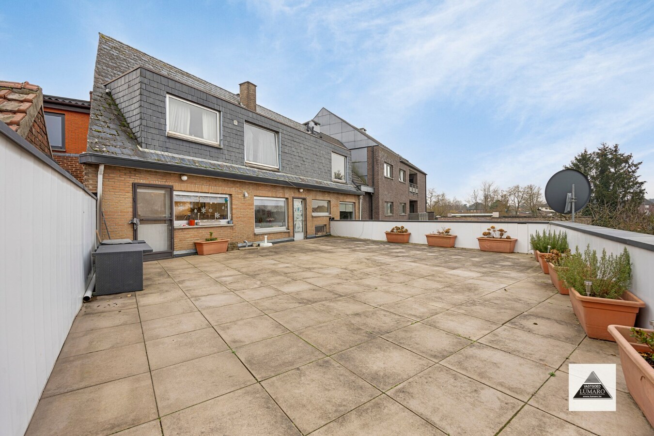 Handelsgelijkvloers en 2 appartementen en parking. Perceel van 15a 49ca. 