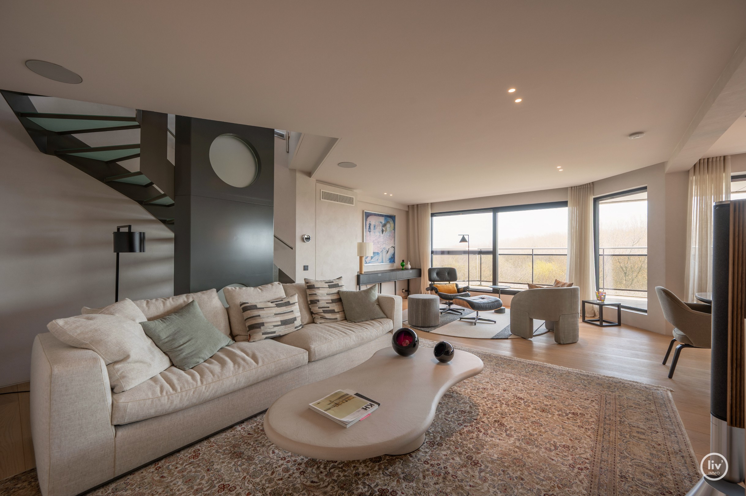 Dit magnifieke duplexappartement combineert uitzonderlijke volumes met adembenemende zichten over zowel de omliggende bossen als de zee. 