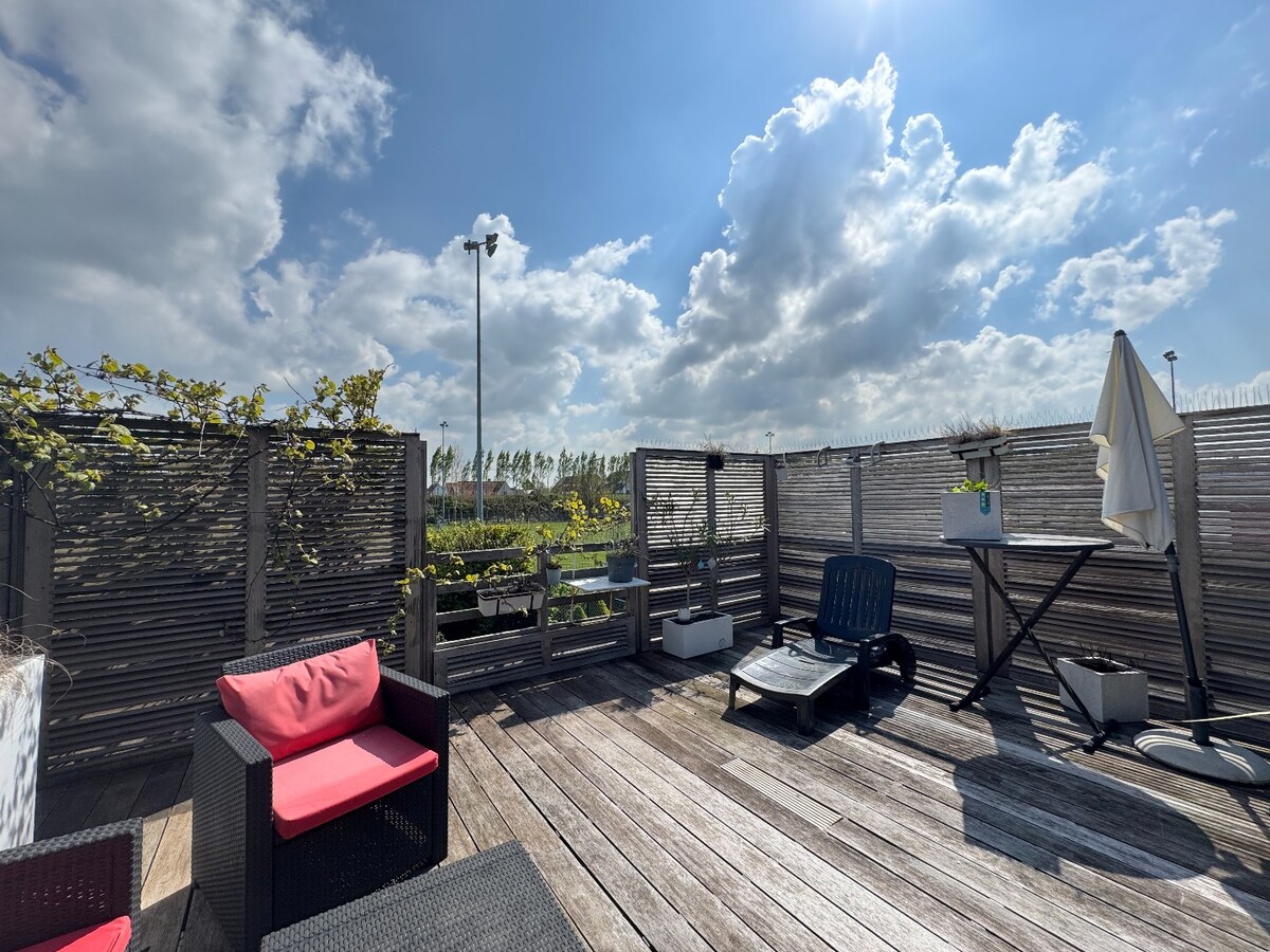 Ruime en veelzijdige bel-étagewoning met 5 slaapkamers, zuidgerichte terrassen en studio/praktijkruimte nabij de zeedijk. 