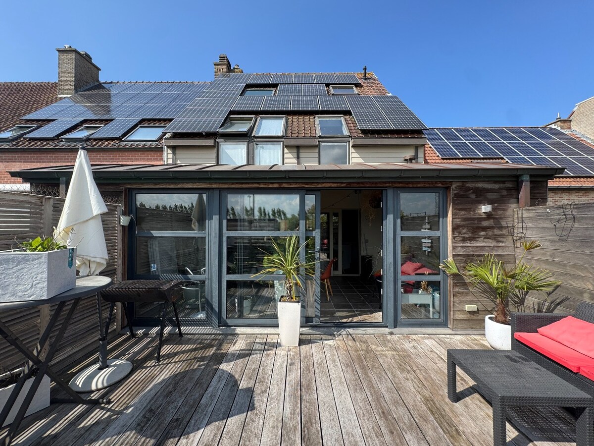 Ruime en veelzijdige bel-étagewoning met 5 slaapkamers, zuidgerichte terrassen en studio/praktijkruimte nabij de zeedijk. 