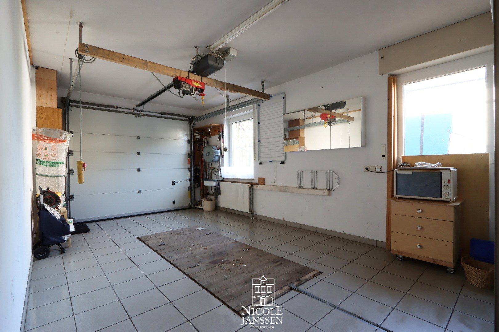 Ruime inpandige garage met tegelvloer en automatische sectionaal poort 