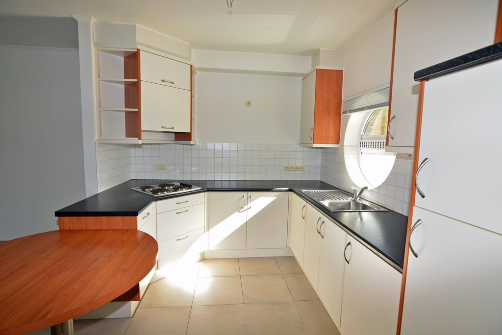 Gelijkvloers appartement (121 m²) met 2 slpks, overdekt terras, garage en kelderberging. 
