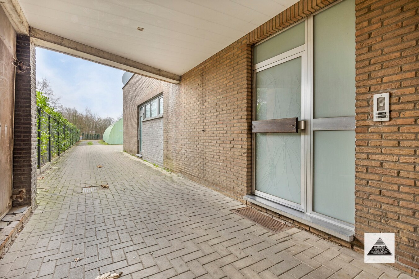 Handelsgelijkvloers en 2 appartementen en parking. Perceel van 15a 49ca. 