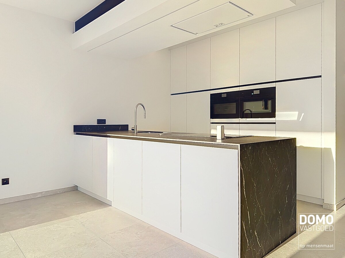 HOOGWAARDIG AFGEWERKT APPARTEMENT VAN 122,50 M² MET 2 SLAAPKAMERS, RUIM TERRAS EN PARKEERPLAATS TE CENTRUM TUILT 