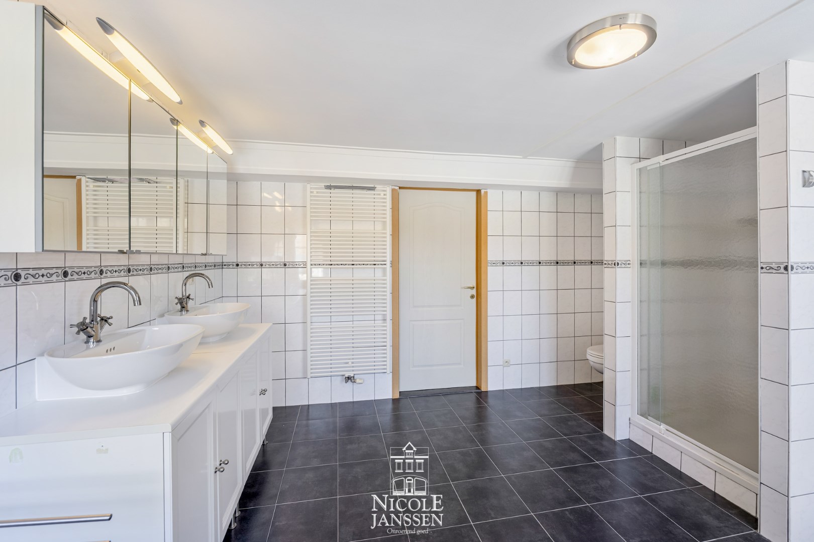 Badkamer met douche, toilet en dubbele lavabo in fraai badkamermeubel 