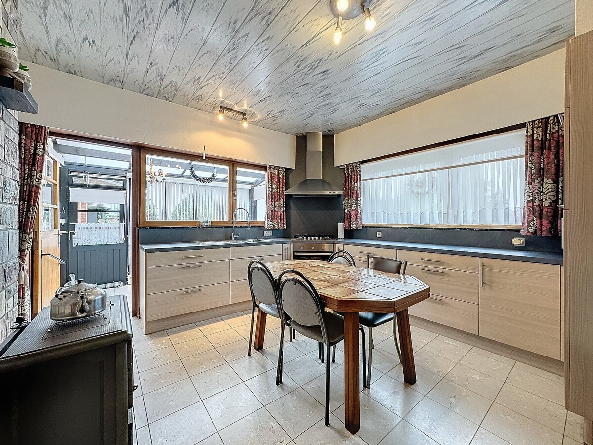 Seventies laagbouw met 2 garages en tuin te Erwetegem 