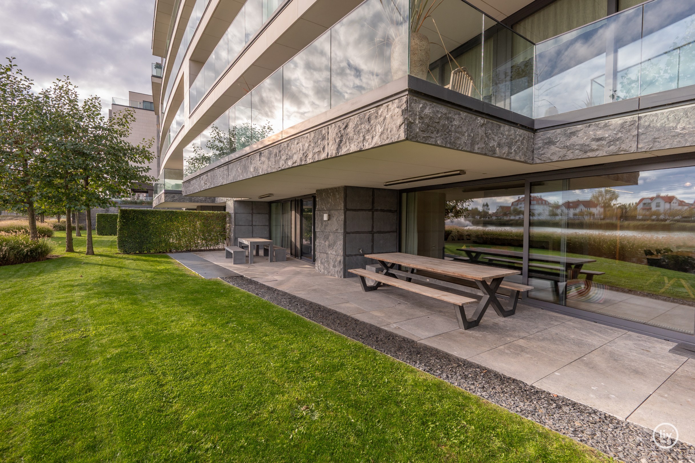Breed en luxueus afgewerkt tuinappartement met wijde zichten op het meer. 