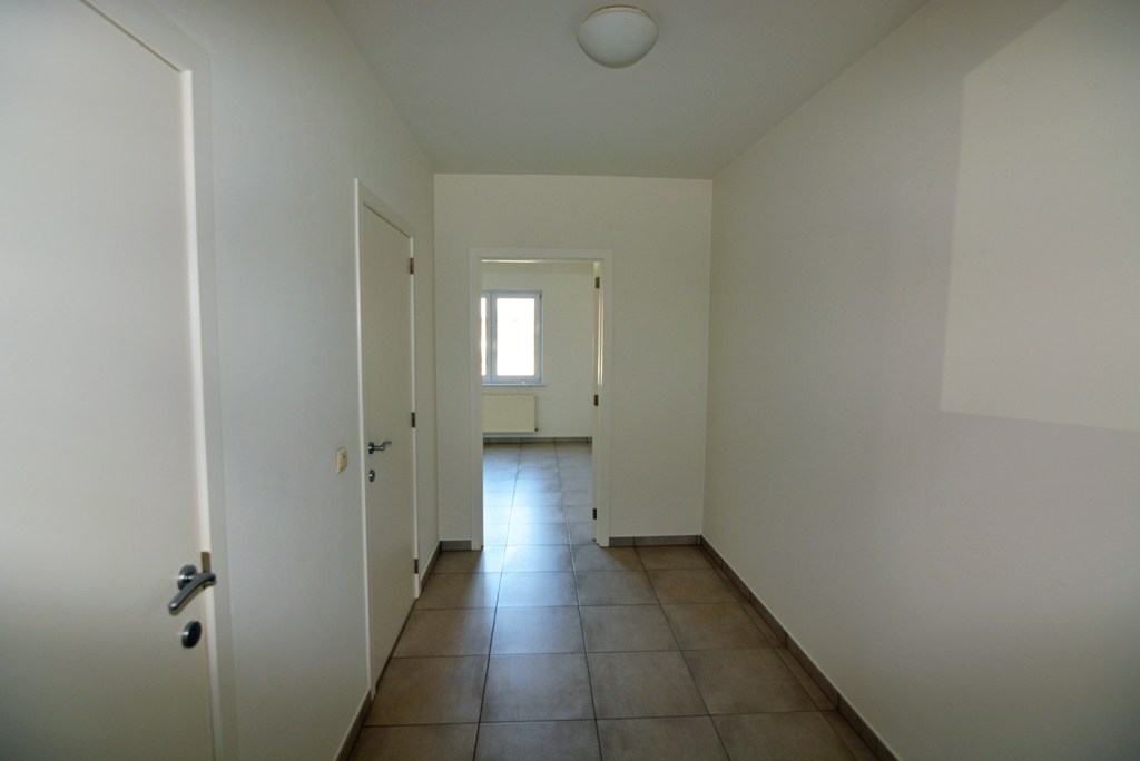 Gelijkvloers appartement (121 m²) met 2 slpks, overdekt terras, garage en kelderberging. 