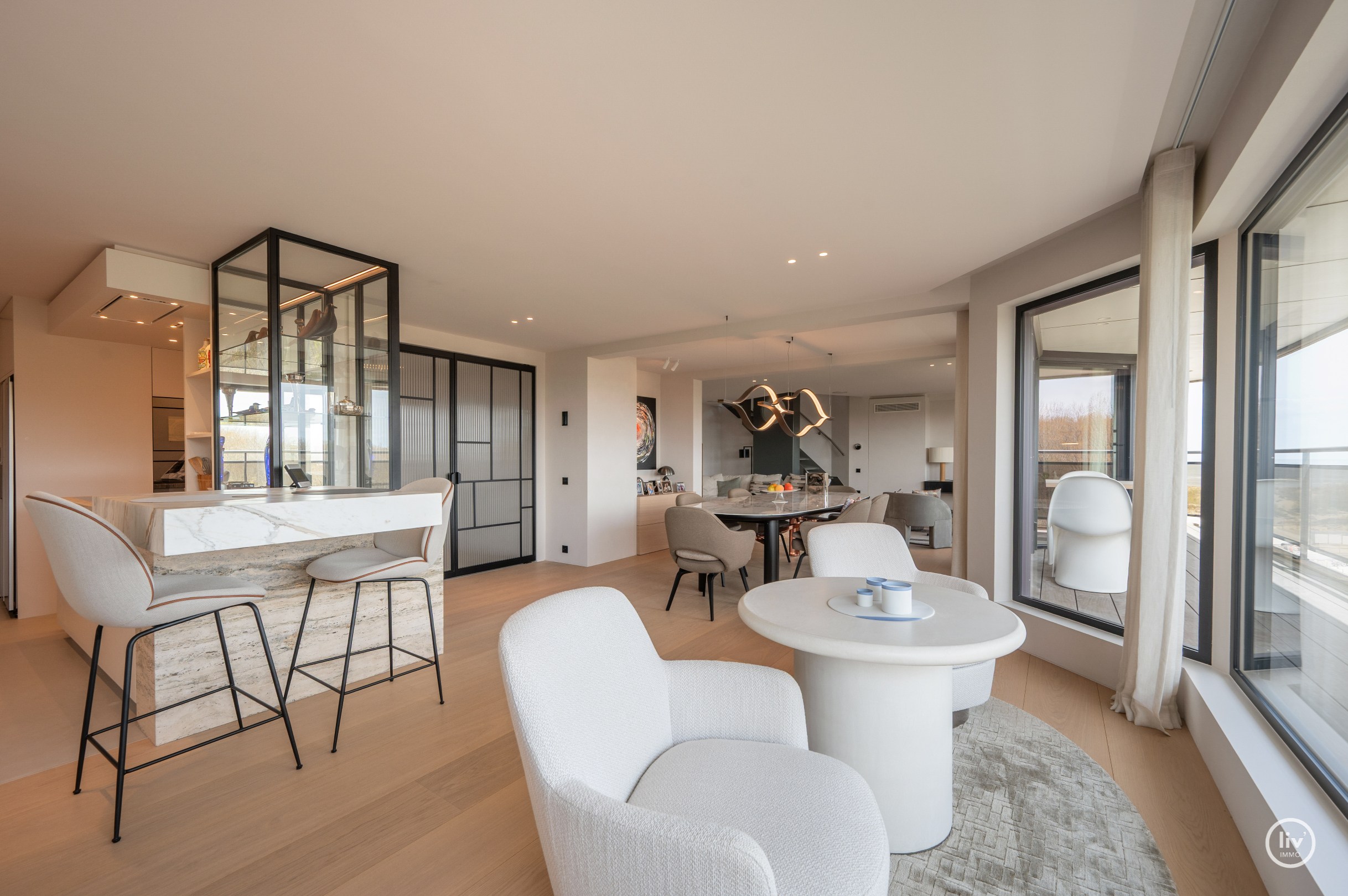 Dit magnifieke duplexappartement combineert uitzonderlijke volumes met adembenemende zichten over zowel de omliggende bossen als de zee. 