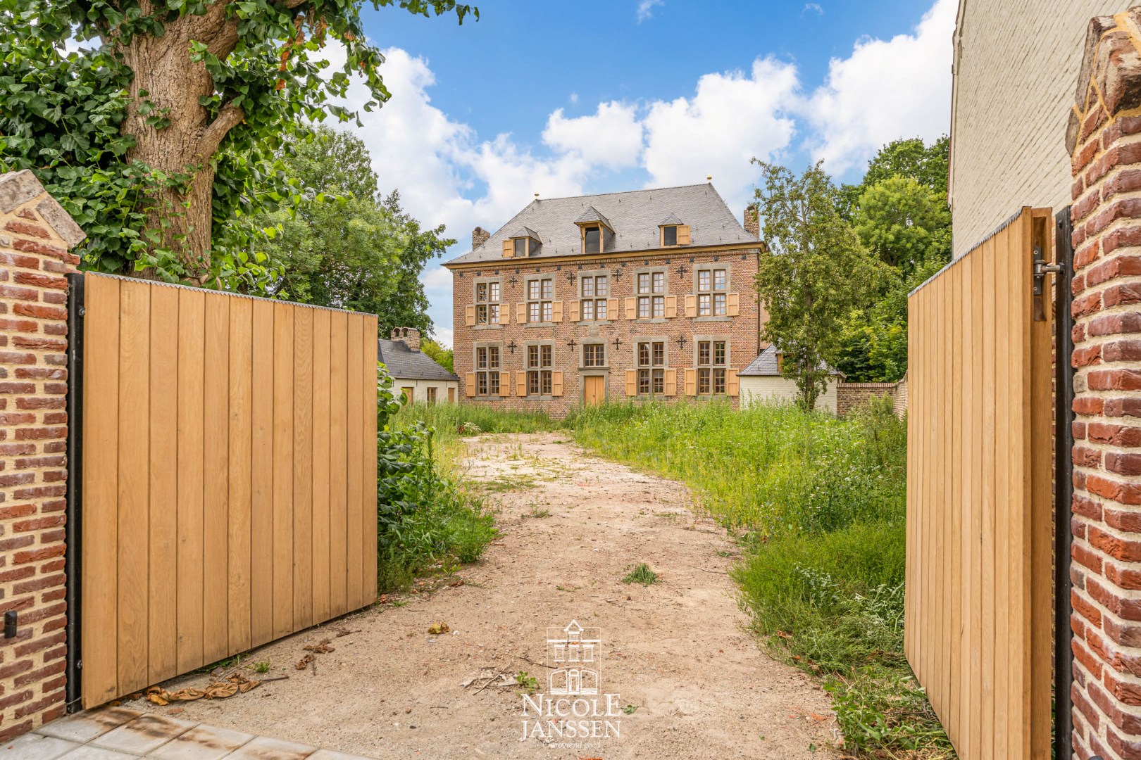Toegang via houten poort aan de Tongerlostraat 