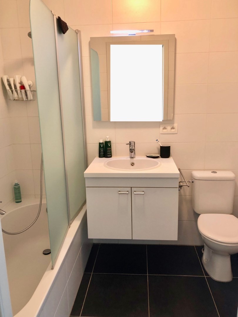 Badkamer met lavabo, toilet en bad/douchecombinatie