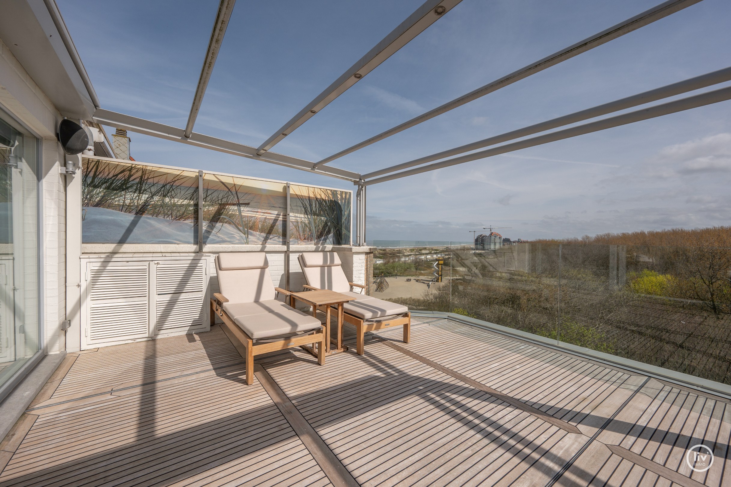 Dit magnifieke duplexappartement combineert uitzonderlijke volumes met adembenemende zichten over zowel de omliggende bossen als de zee. 