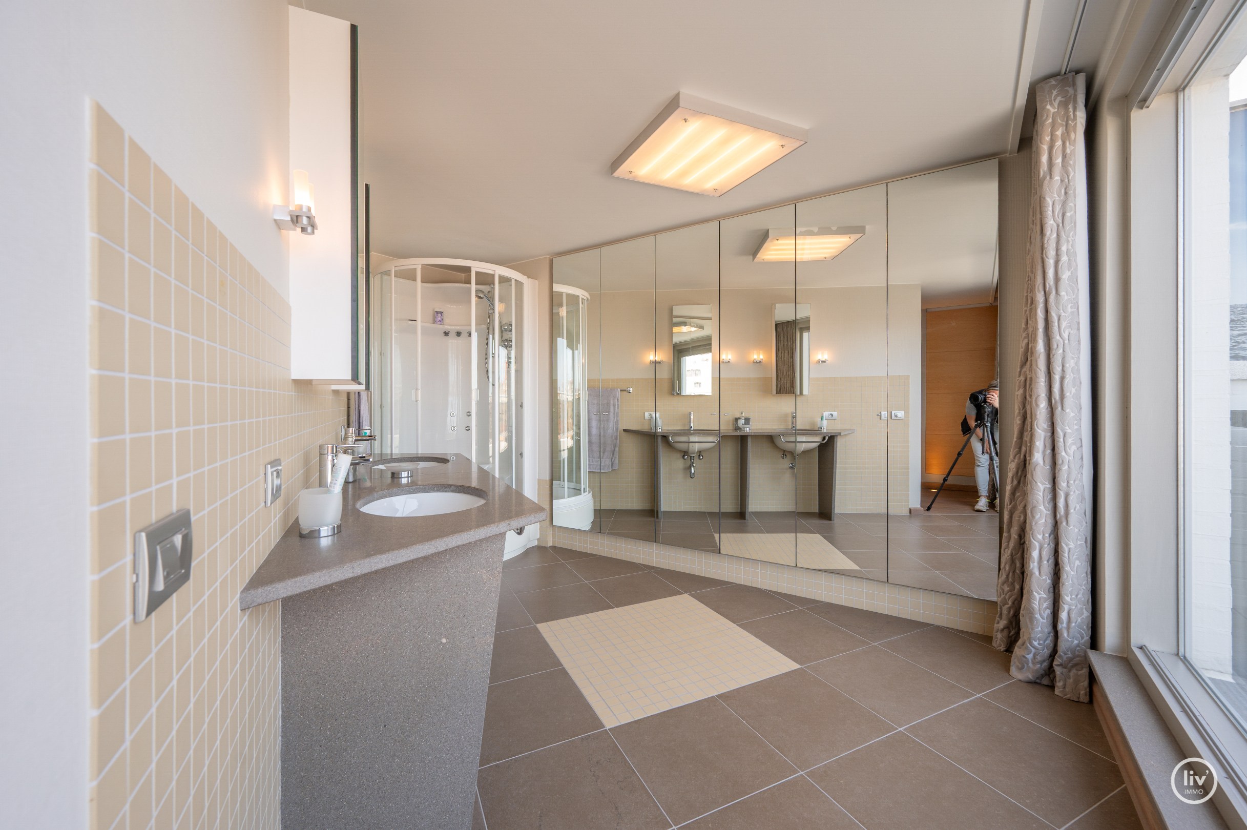 Dit magnifieke duplexappartement combineert uitzonderlijke volumes met adembenemende zichten over zowel de omliggende bossen als de zee. 