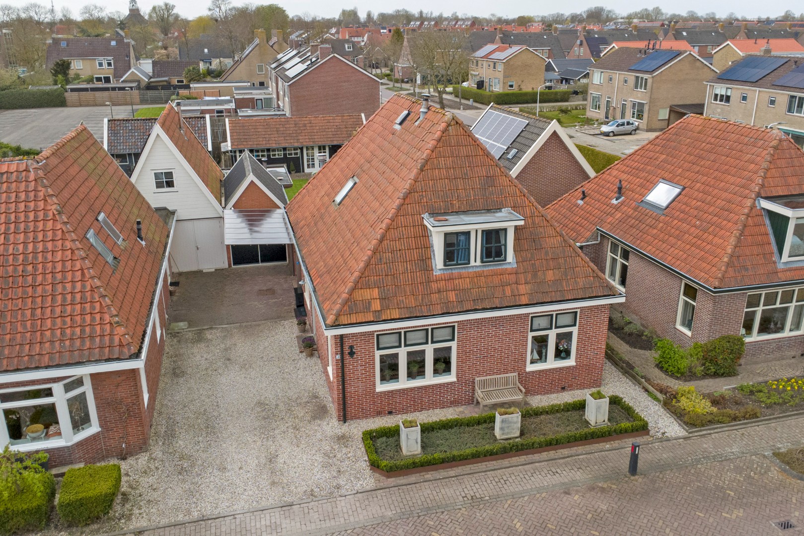 Vrijstaande woning met diepe zonnige tuin, overkapping en royale bijgebouwen 