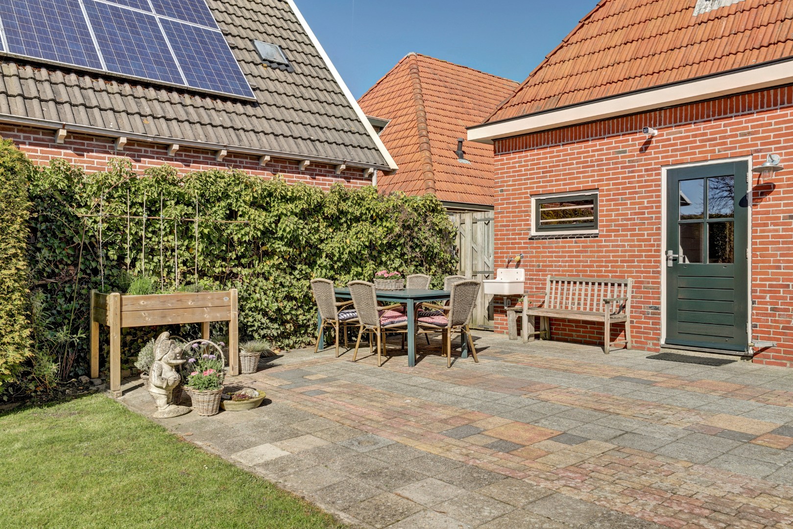 Vrijstaande woning met diepe zonnige tuin, overkapping en royale bijgebouwen 