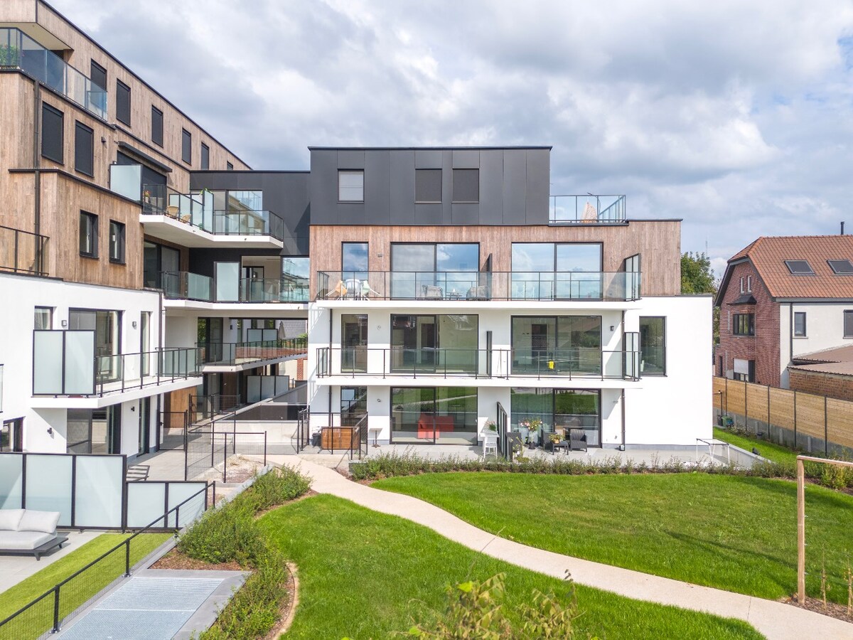 Gelijkvloers nieuwbouwapp. met tuin en garage, centrum Herzele 