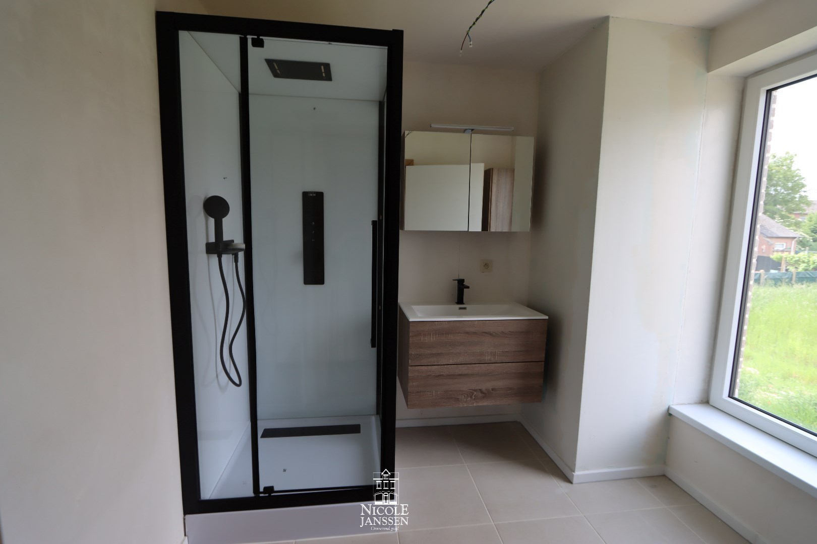 Badkamer met douche en enkele wastafel in badkamermeubel