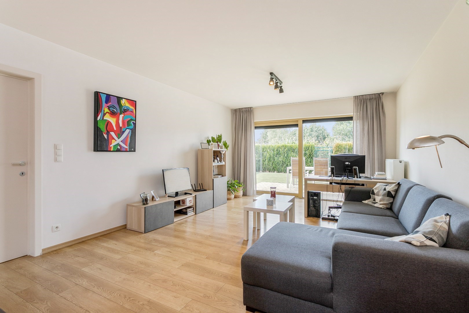 Modern, gelijkvloers appartement met 2 slpk, ondergrondse parking en tuin. 