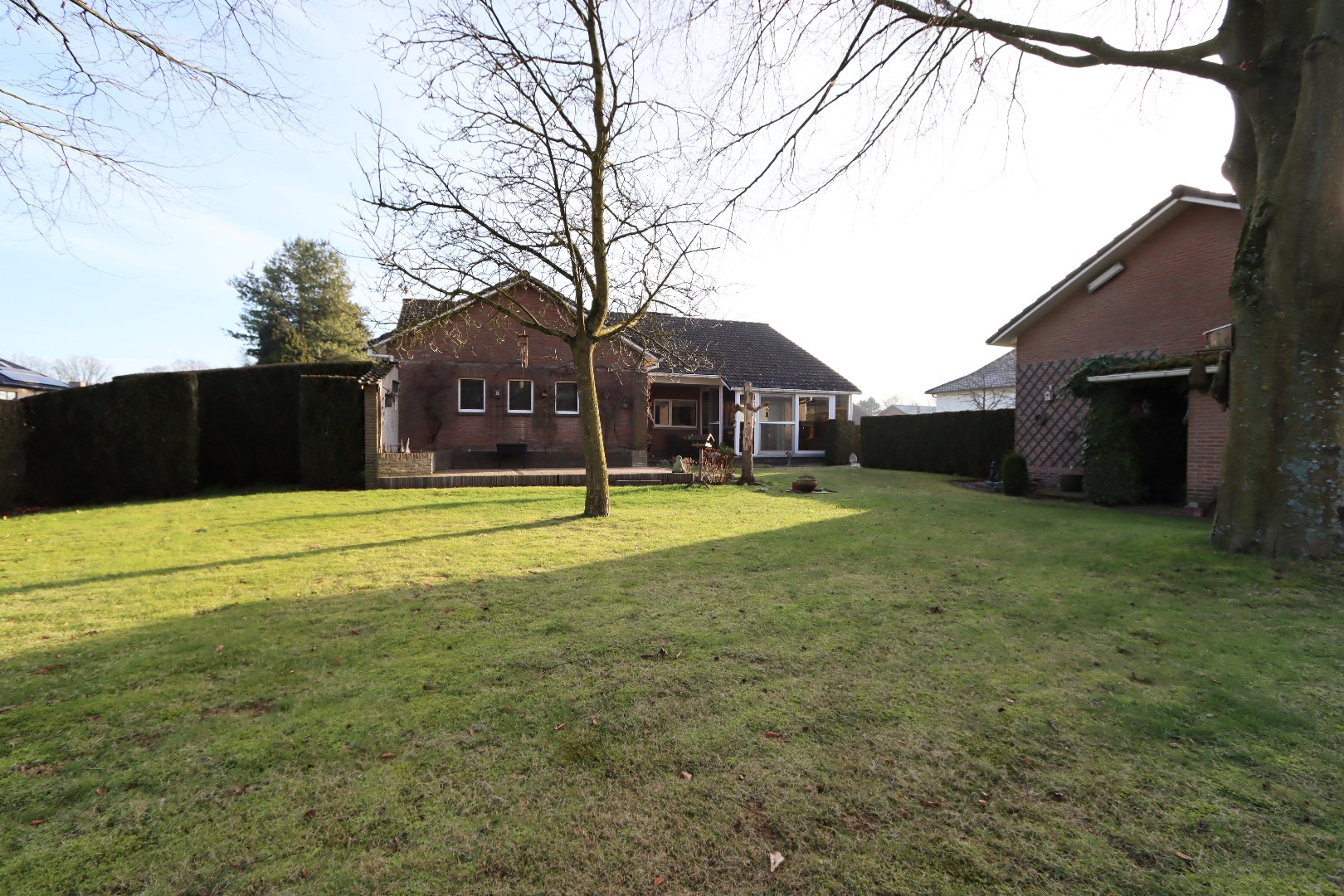 Diepe achtertuin met tuinberging 