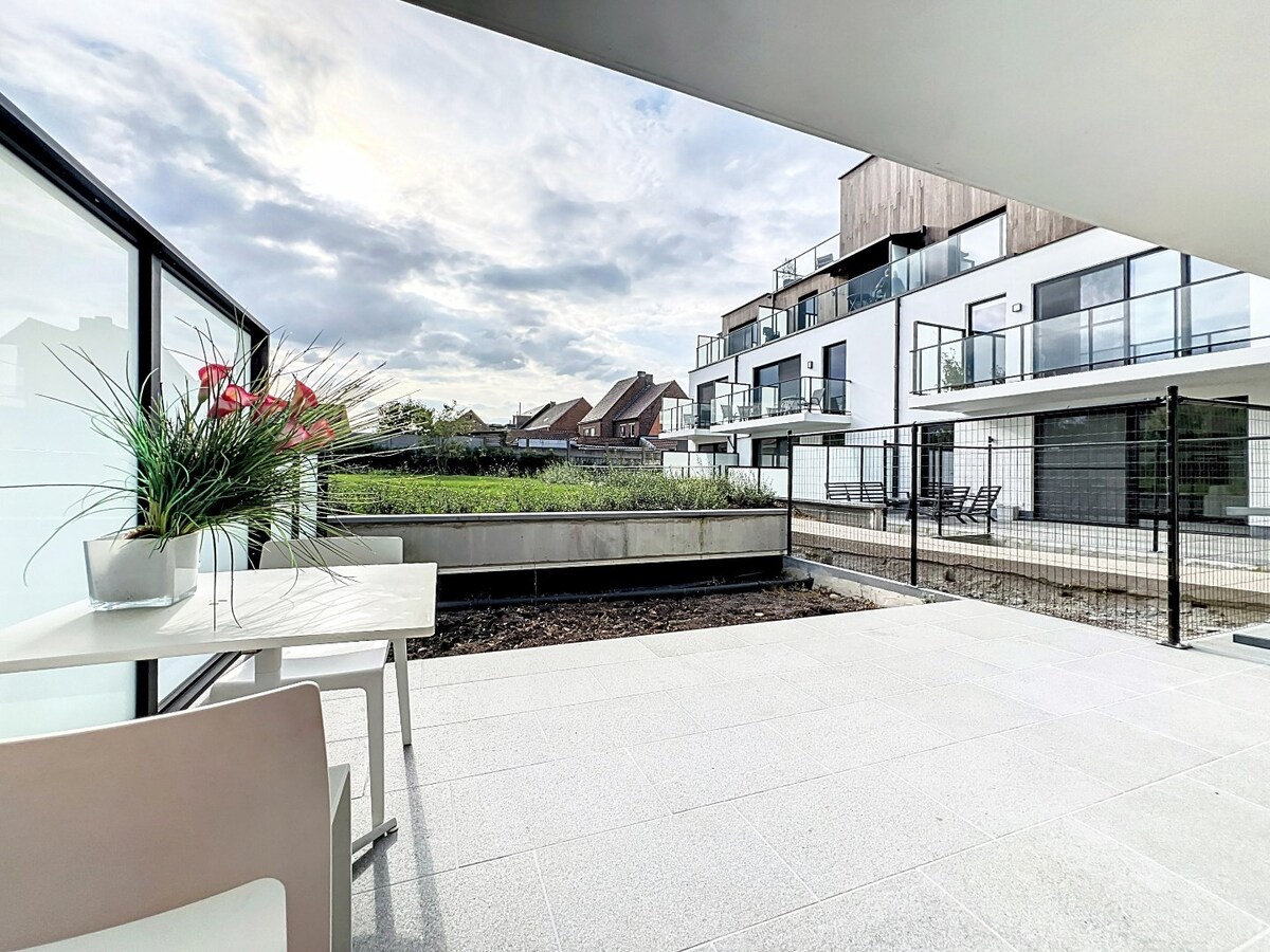 Gelijkvloers nieuwbouwapp. met tuin en garage, centrum Herzele 