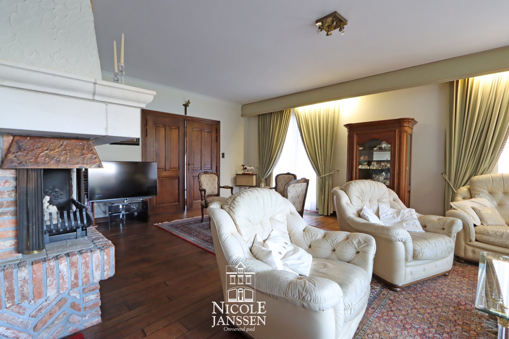 L-vormige woonkamer met parketvloer en gashaard 