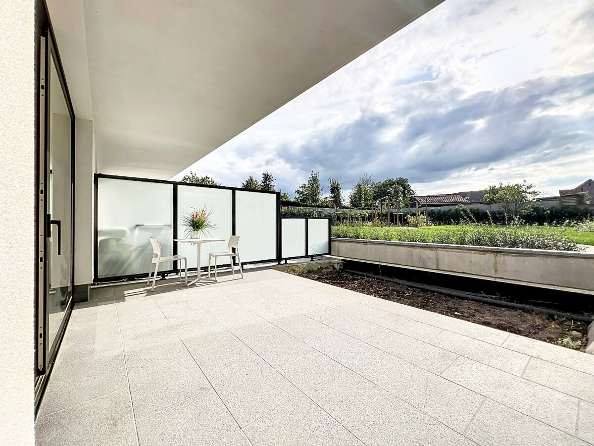 Gelijkvloers nieuwbouwapp. met tuin en garage, centrum Herzele 