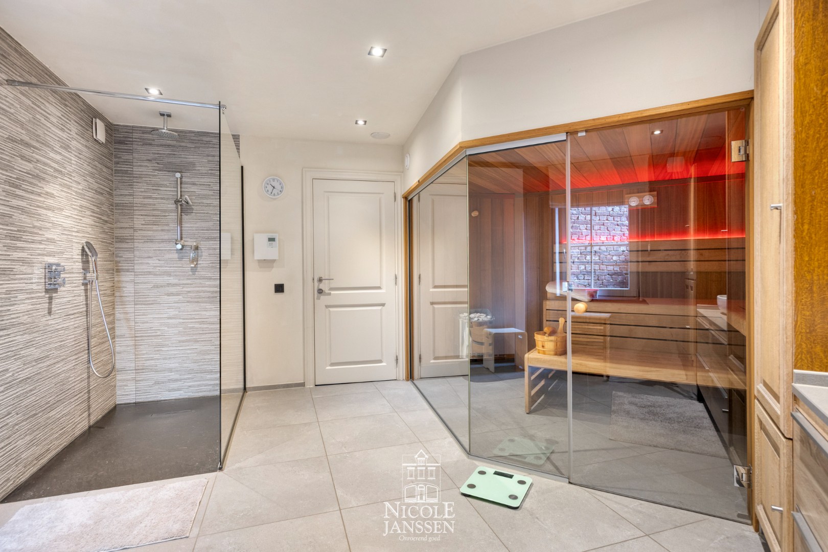 Badkamer voorzien van dubbele wastafel, inloopdouche en sauna