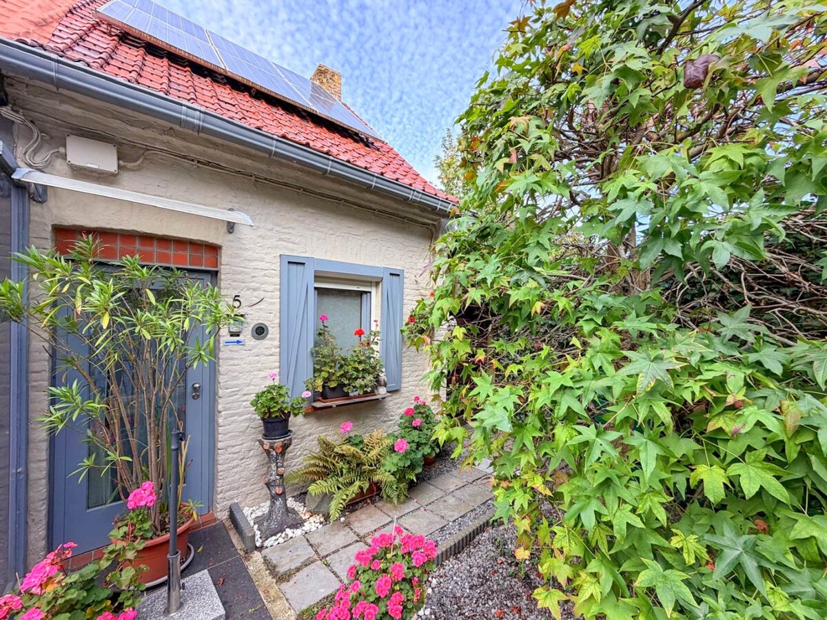 Knusse woning met ruime tuin en uitweg en mogelijkheid tot aankoop van een garage. 