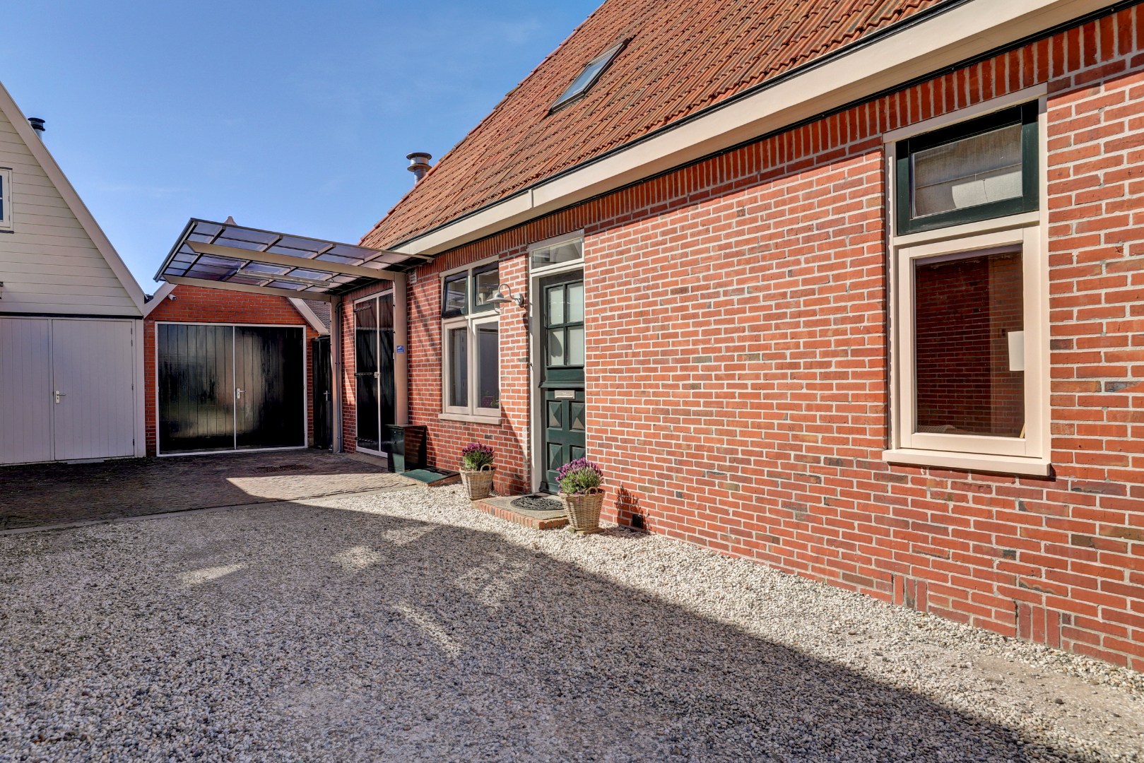 Vrijstaande woning met diepe zonnige tuin, overkapping en royale bijgebouwen 