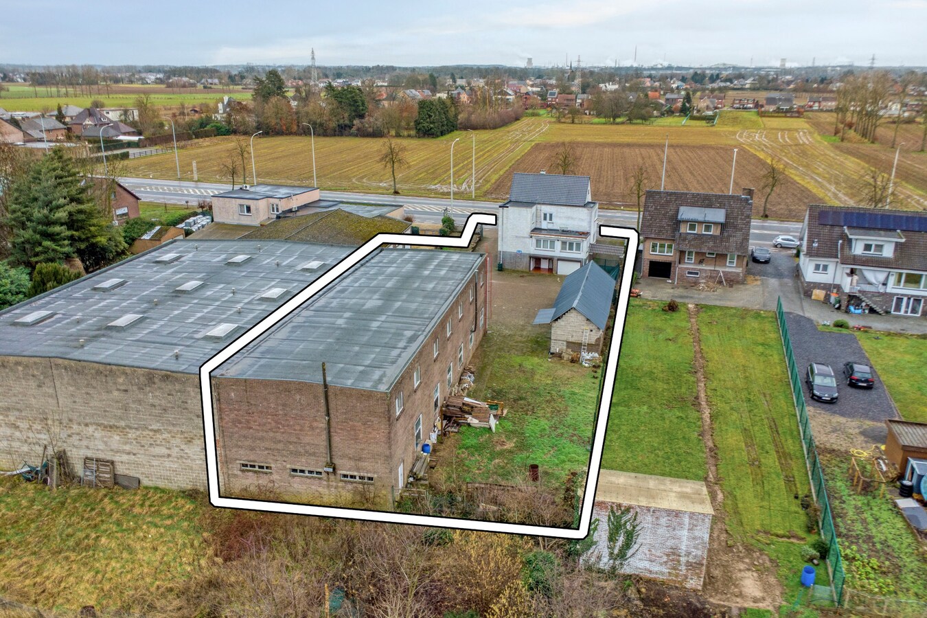Woning met vergunde loods (300 m² x 2) en bijgebouw (50,50 m²). 