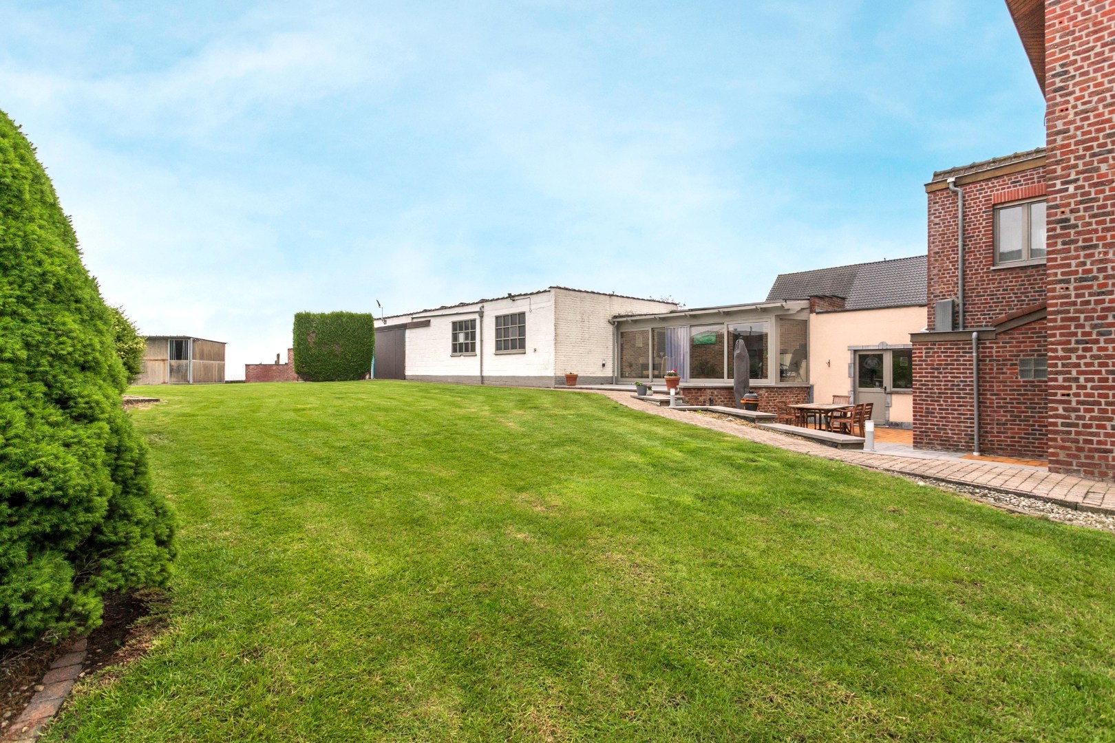 Ruime woning met naastgelegen bouwgrond en loods 