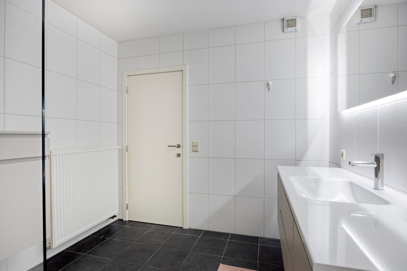 Gelijkvloers appartement met 2 slpk, 2 parkings en 2 kelderbergingen. 