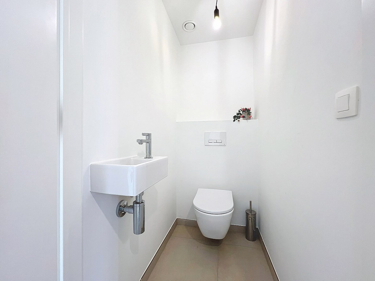 Gelijkvloers nieuwbouwapp. met tuin en garage, centrum Herzele 