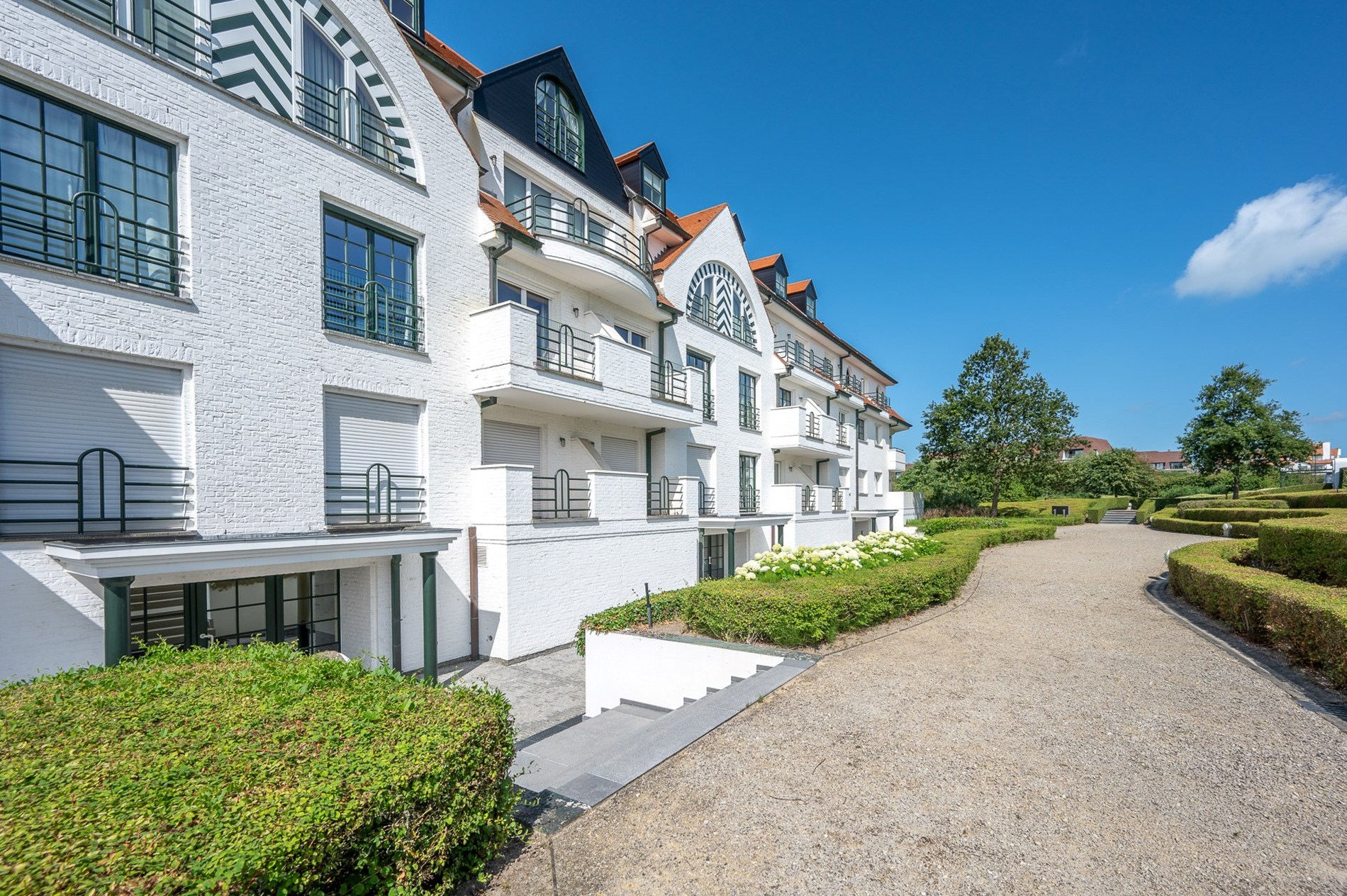 Appartement d'angle exceptionnellement rénové situé au cœur du Zoute, dans le domaine très exclusif Tennis Gardens - un parc privé d'environ 5 hectares, à proximité de la mer et à distance de marche d 