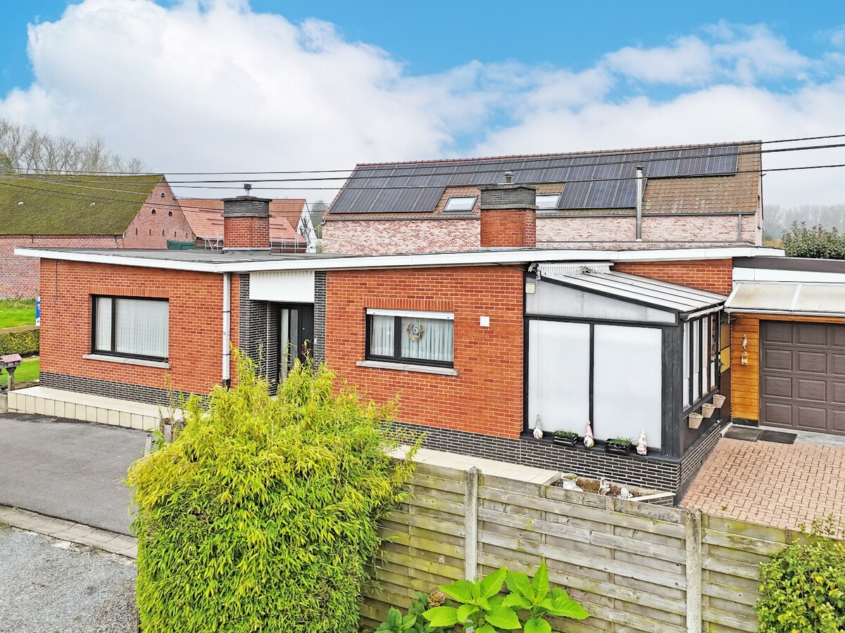 Seventies laagbouw met 2 garages en tuin te Erwetegem 