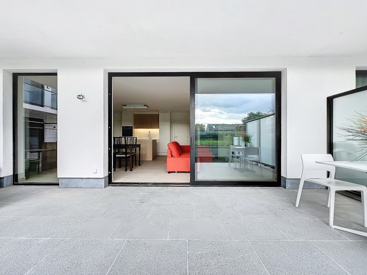 Gelijkvloers nieuwbouwapp. met tuin en garage, centrum Herzele 