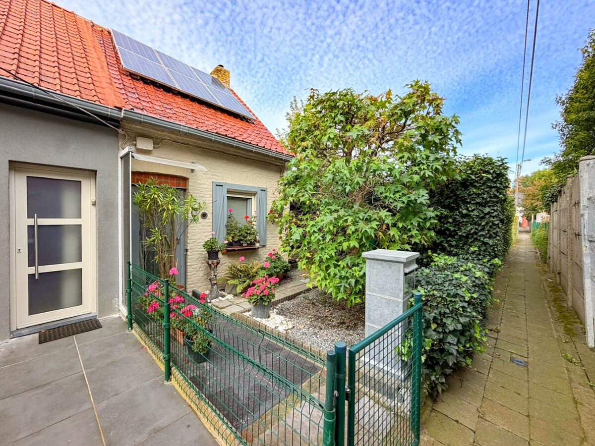 Knusse woning met ruime tuin en uitweg en mogelijkheid tot aankoop van een garage. 