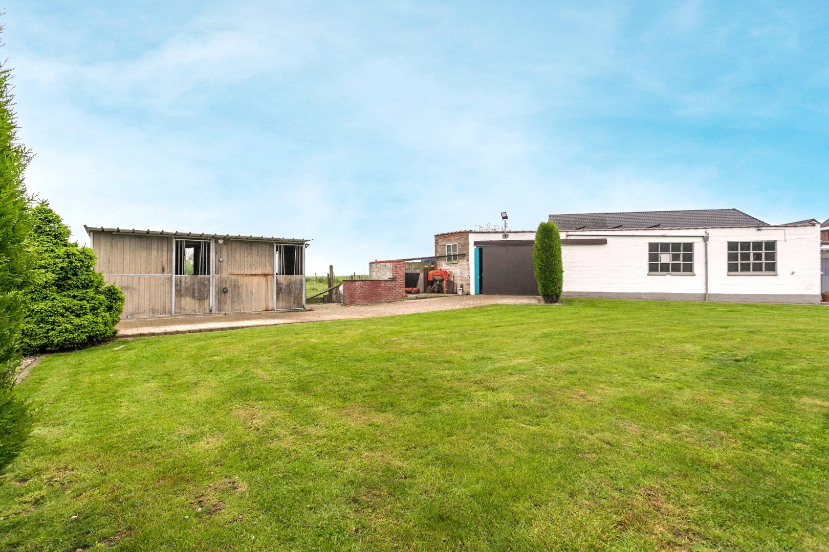 Ruime woning met naastgelegen bouwgrond en loods 