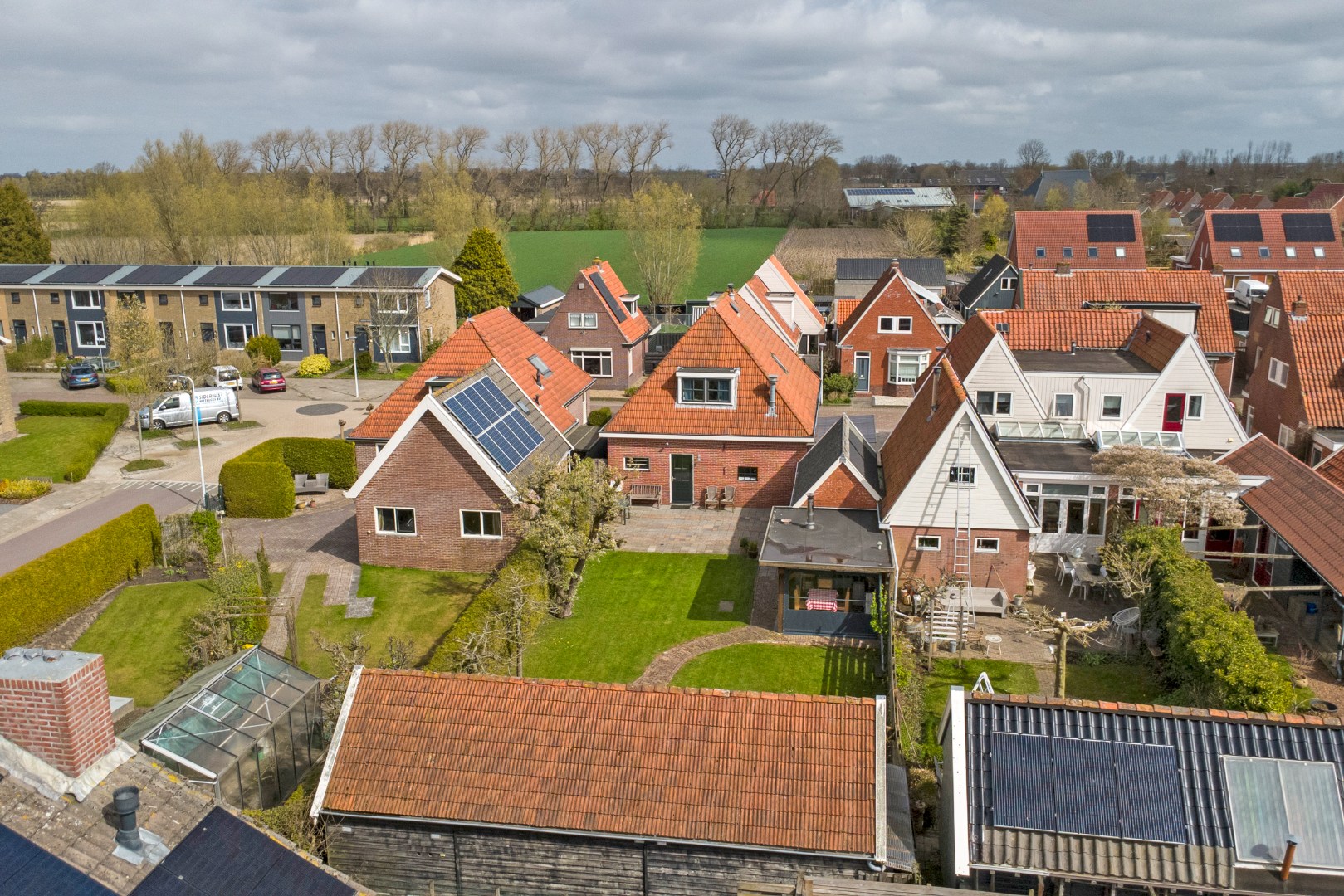 Vrijstaande woning met diepe zonnige tuin, overkapping en royale bijgebouwen 