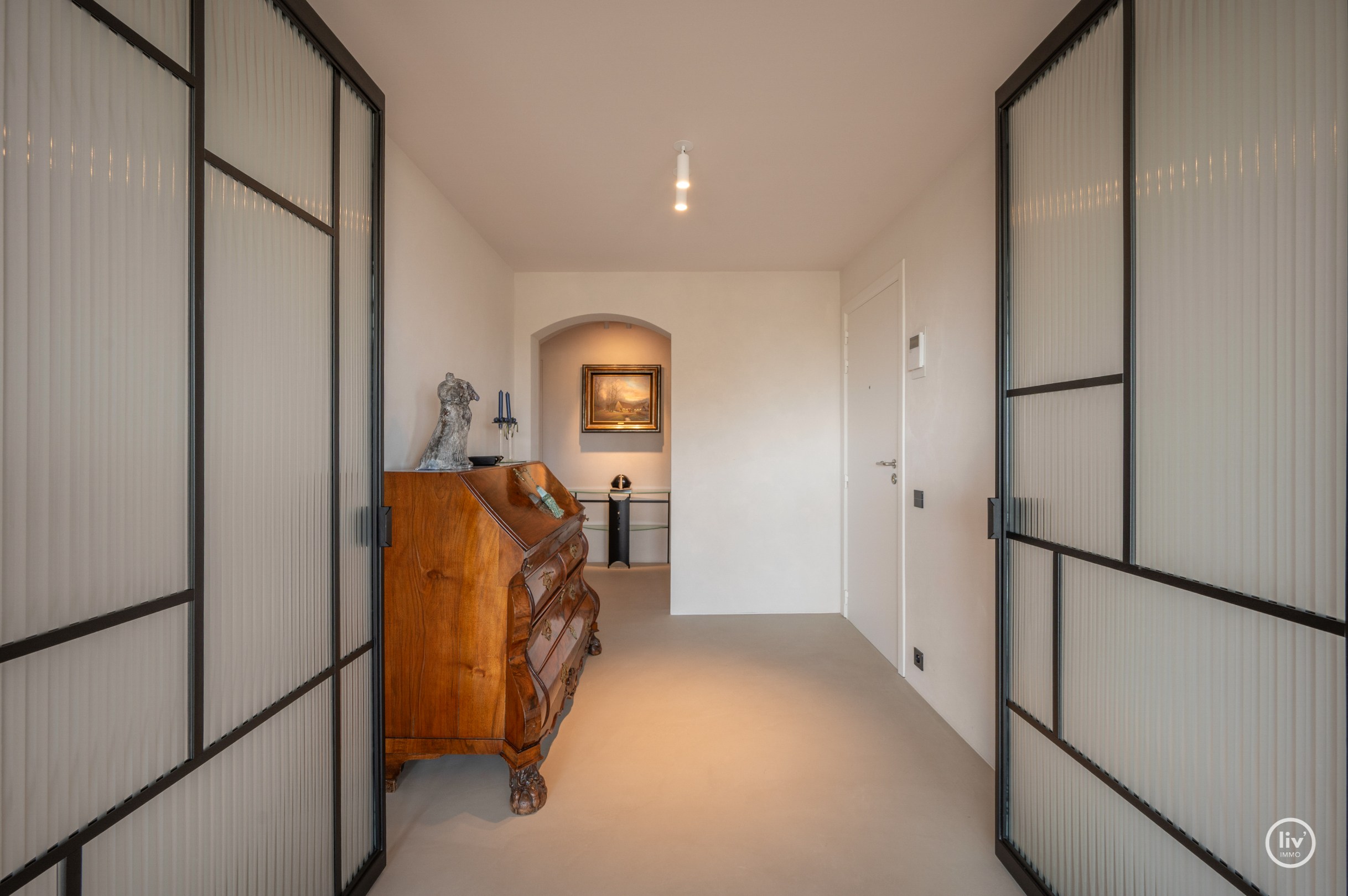 Dit magnifieke duplexappartement combineert uitzonderlijke volumes met adembenemende zichten over zowel de omliggende bossen als de zee. 