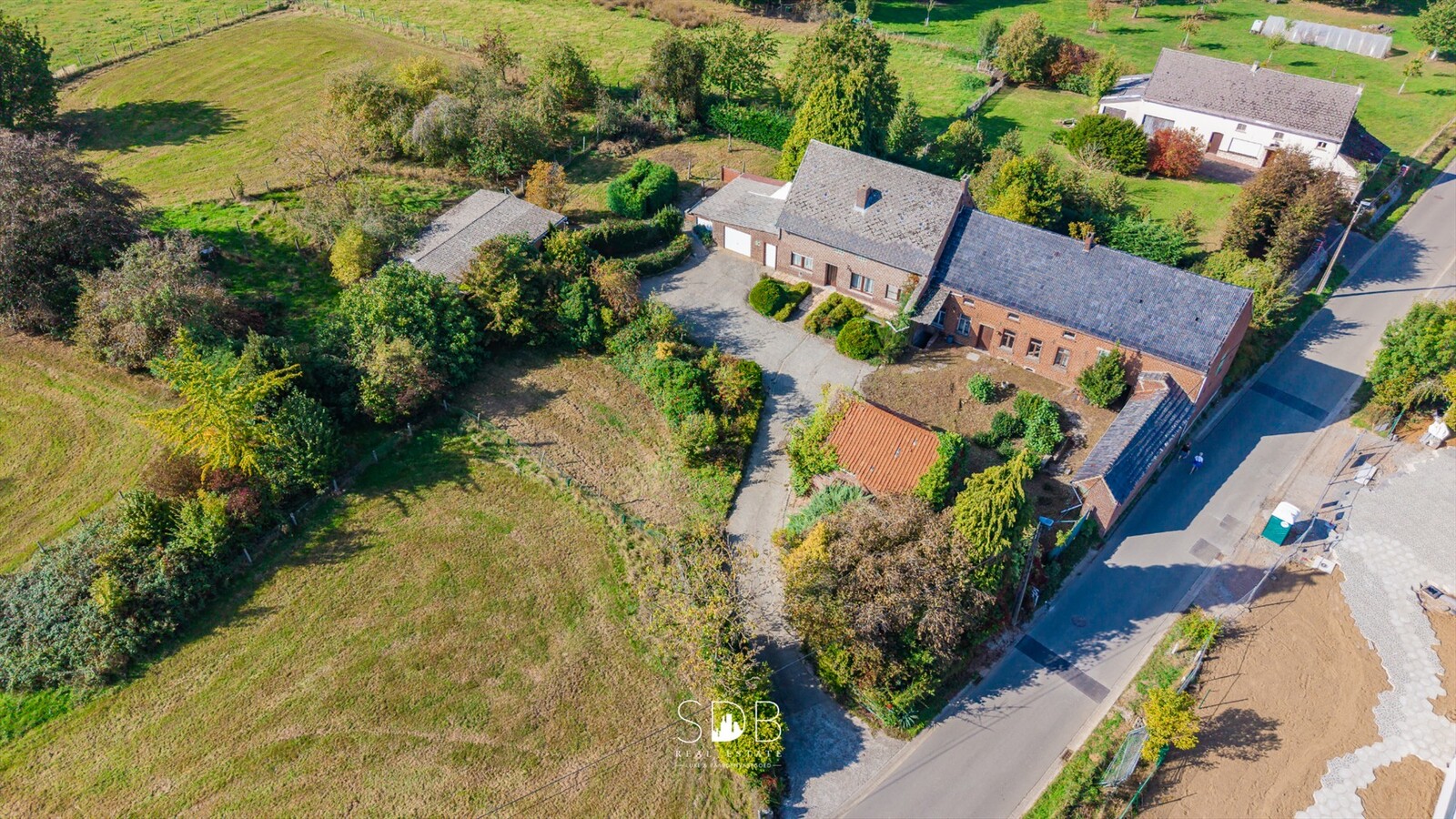 Landelijke hoeve met bijgebouwen en aanpalende graslanden op 14.677m² 