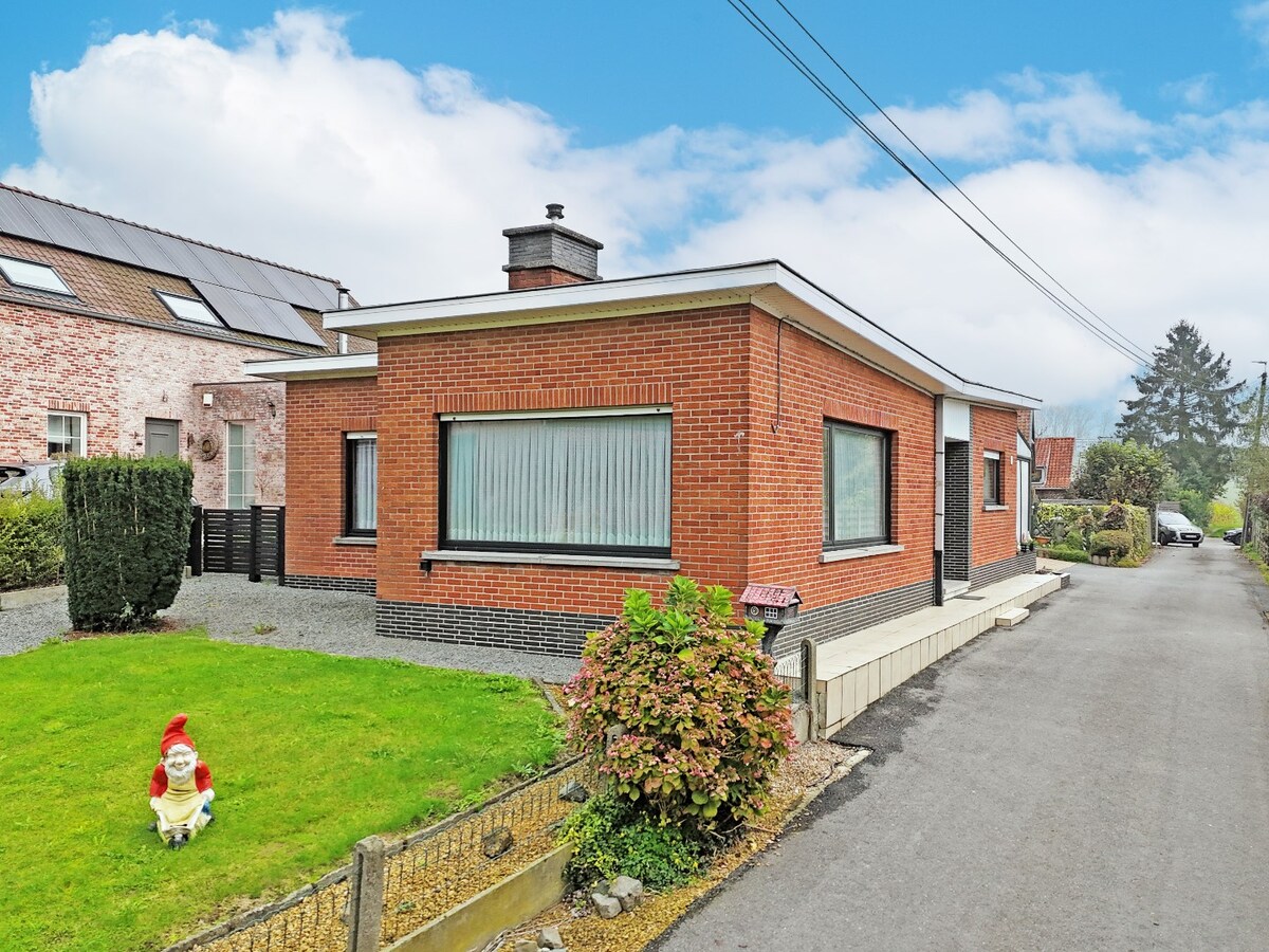 Seventies laagbouw met 2 garages en tuin te Erwetegem 