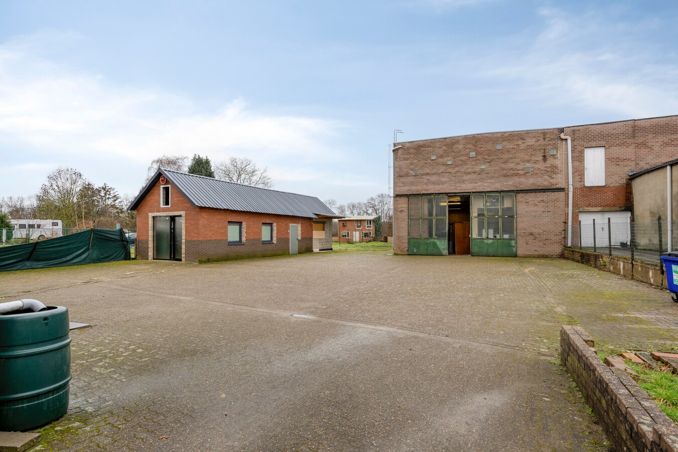 Woning met vergunde loods (300 m² x 2) en bijgebouw (50,50 m²). 