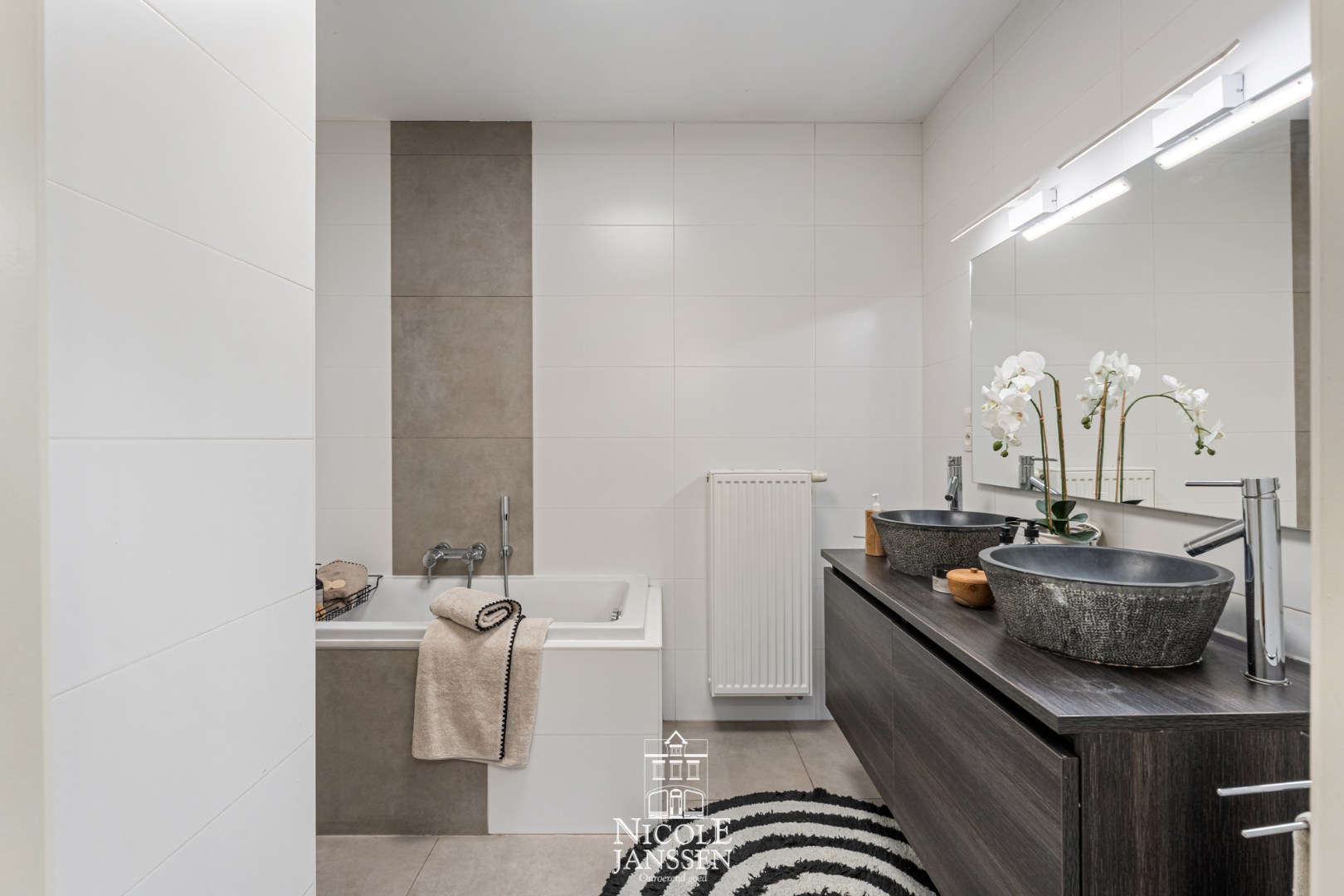 Badkamer met douche, ligbad en dubbele lavabo 