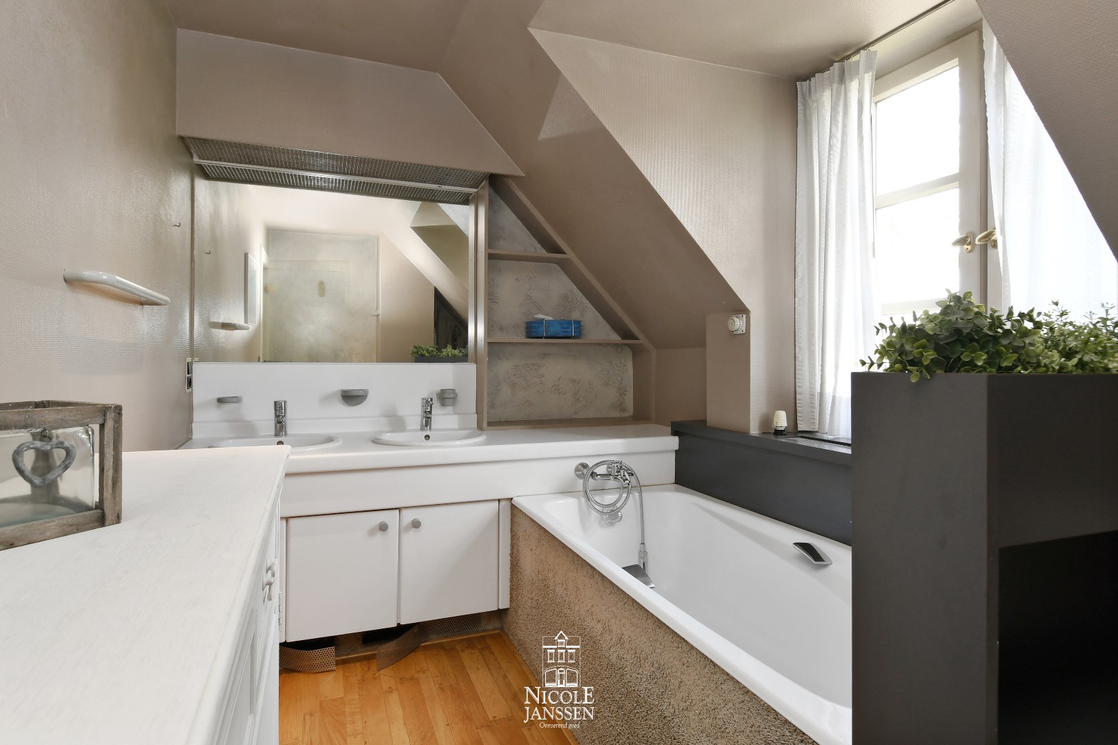 Badkamer met ligbad en dubbele lavabo in badkamermeubel