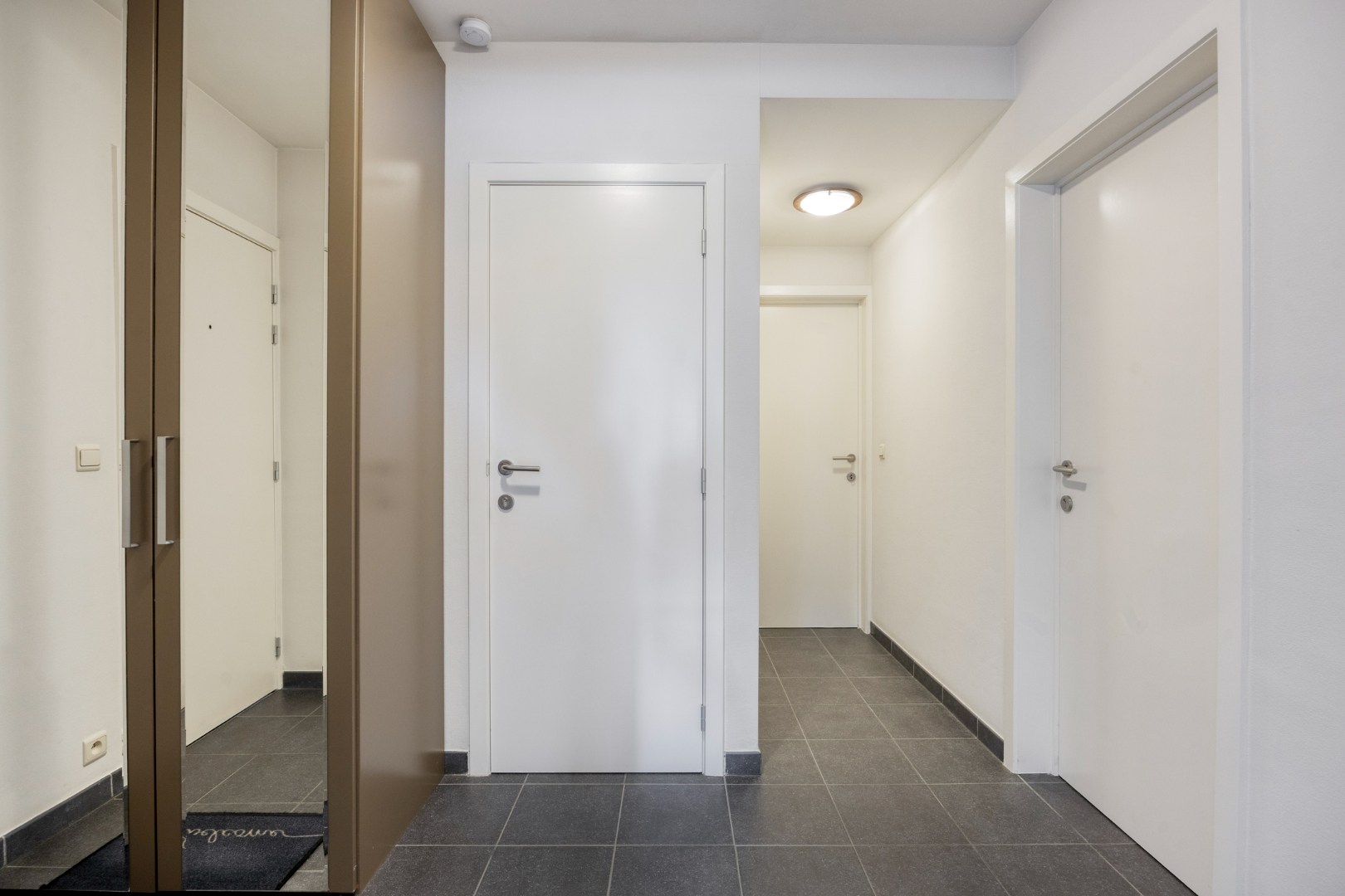 Gelijkvloers appartement met 2 slpk, 2 parkings en 2 kelderbergingen. 