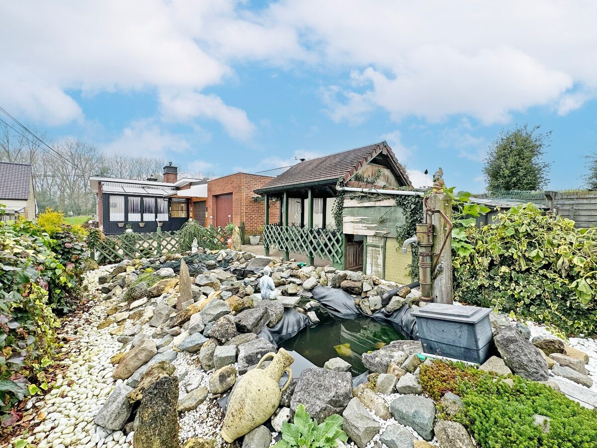 Seventies laagbouw met 2 garages en tuin te Erwetegem 