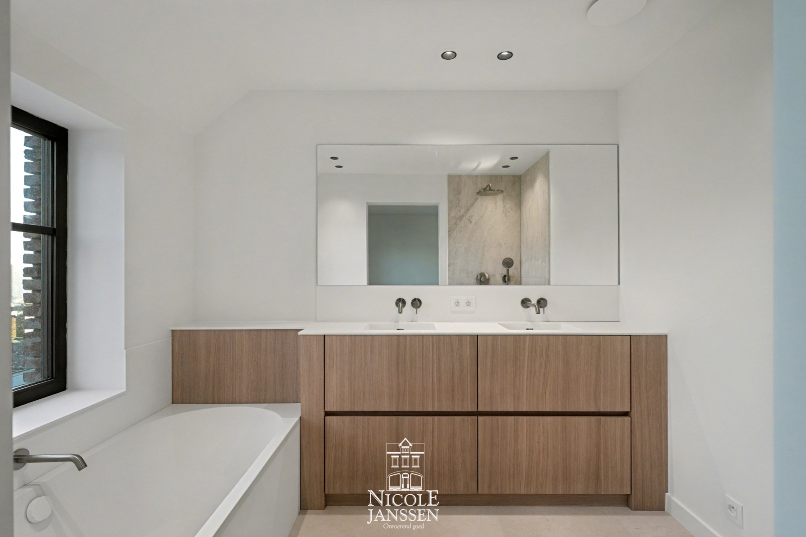 Tweede badkamer met ligbad, dubbele wastafel en douche