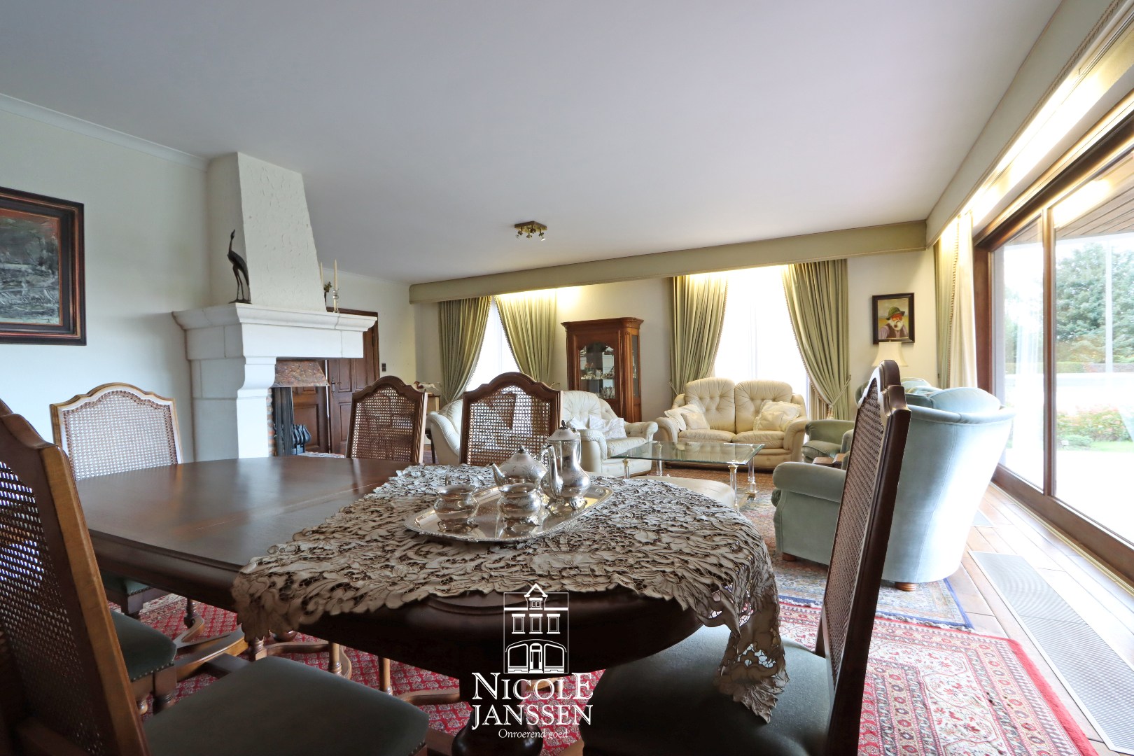 L-vormige woonkamer met parketvloer en gashaard 