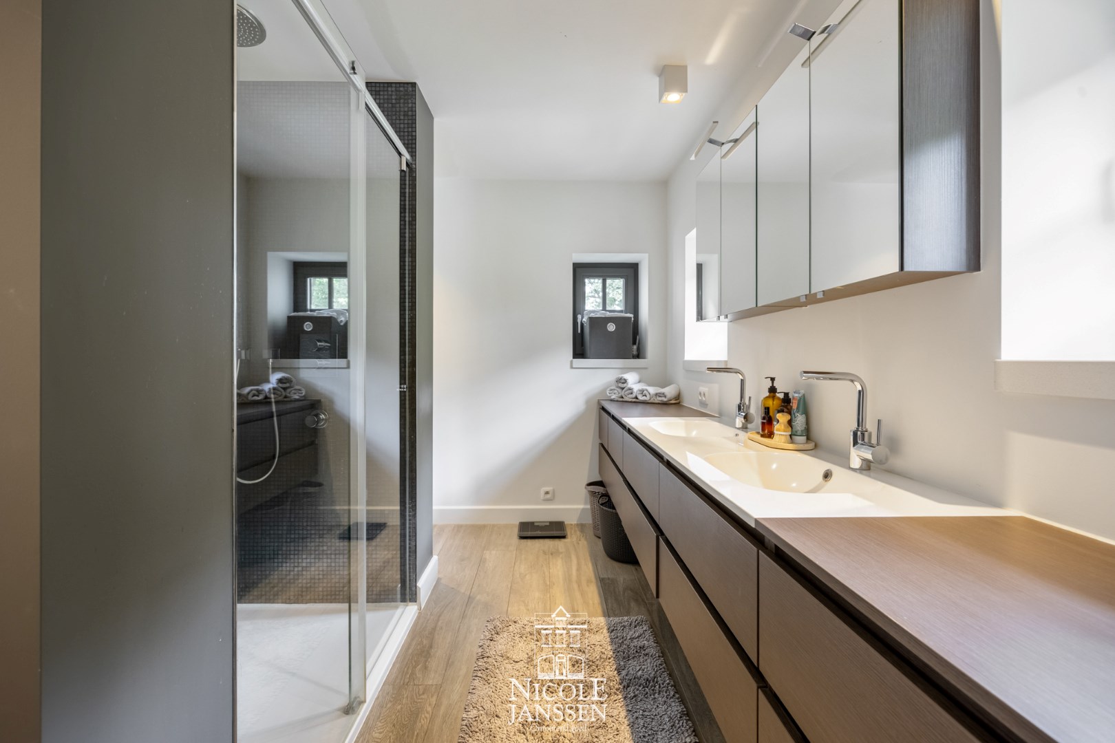 Badkamer met douche en twee wastafels